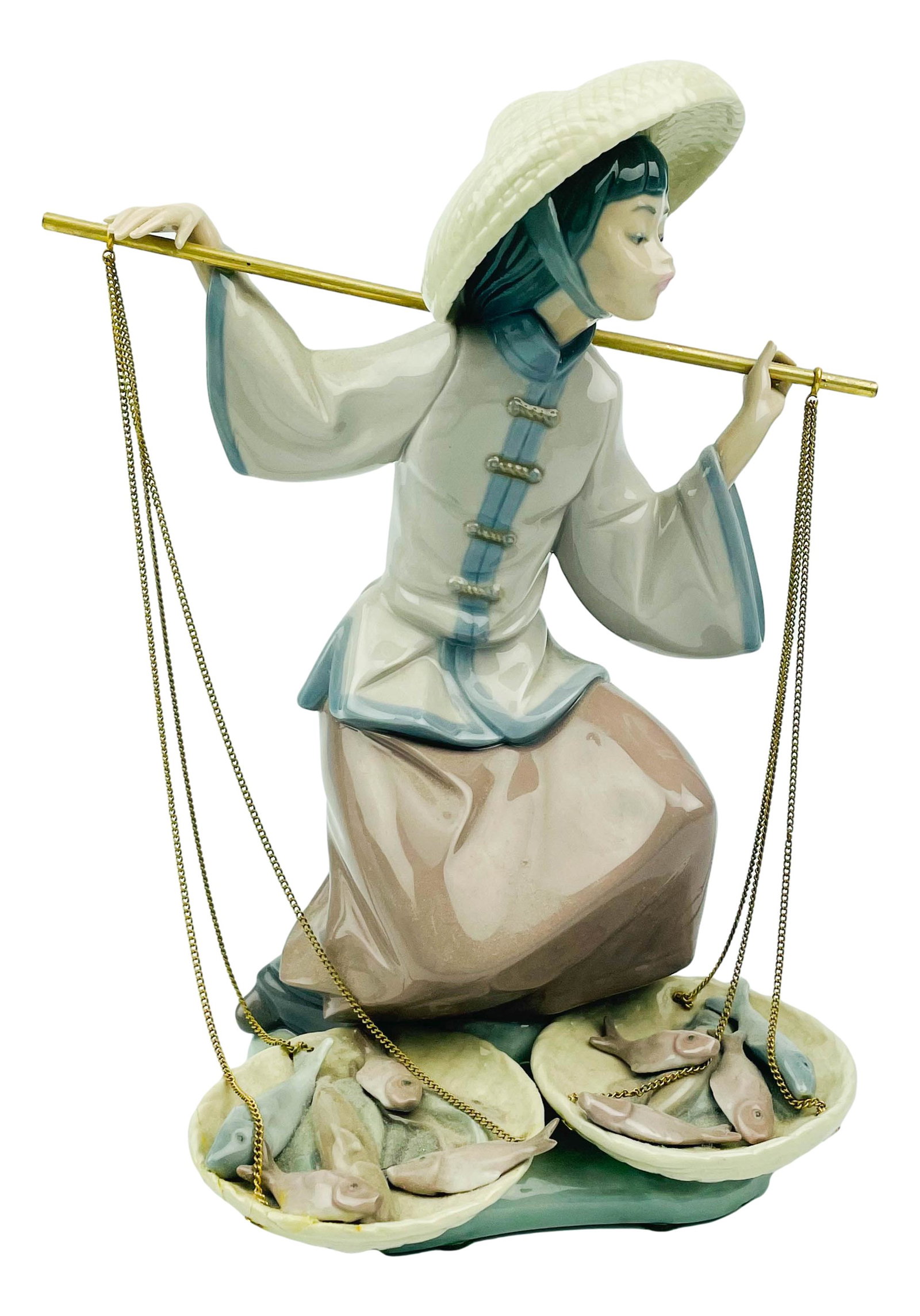 Lladro Spanish Porcelain Chinese Girl Statue #5172: A Lladro Spanish porcelain figurine. Titled, "Chinese Girl in the Market," or "Fish Aplenty," model number 5172, produced circa 1982, designed by artist Salvador Debon. LLADRO backstamp to underside. 