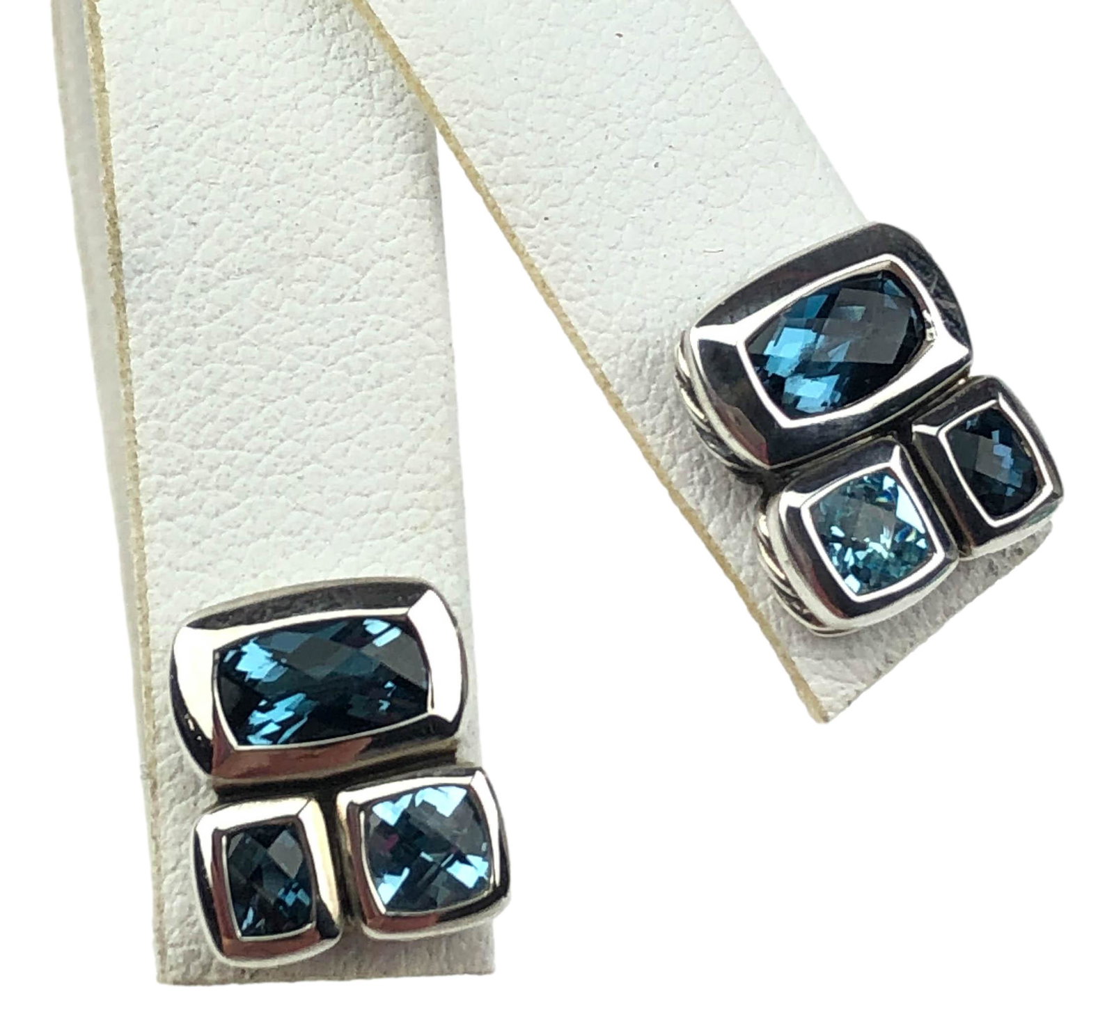 David Yurman Sterling Silver Blue Topaz Earrings: Pair of signed David Yurman earrings. Crafted of sterling silver. Set with three checkerboard faceted blue topaz gemstones in rectangular and square shapes. Classic cable design details. Pierced style