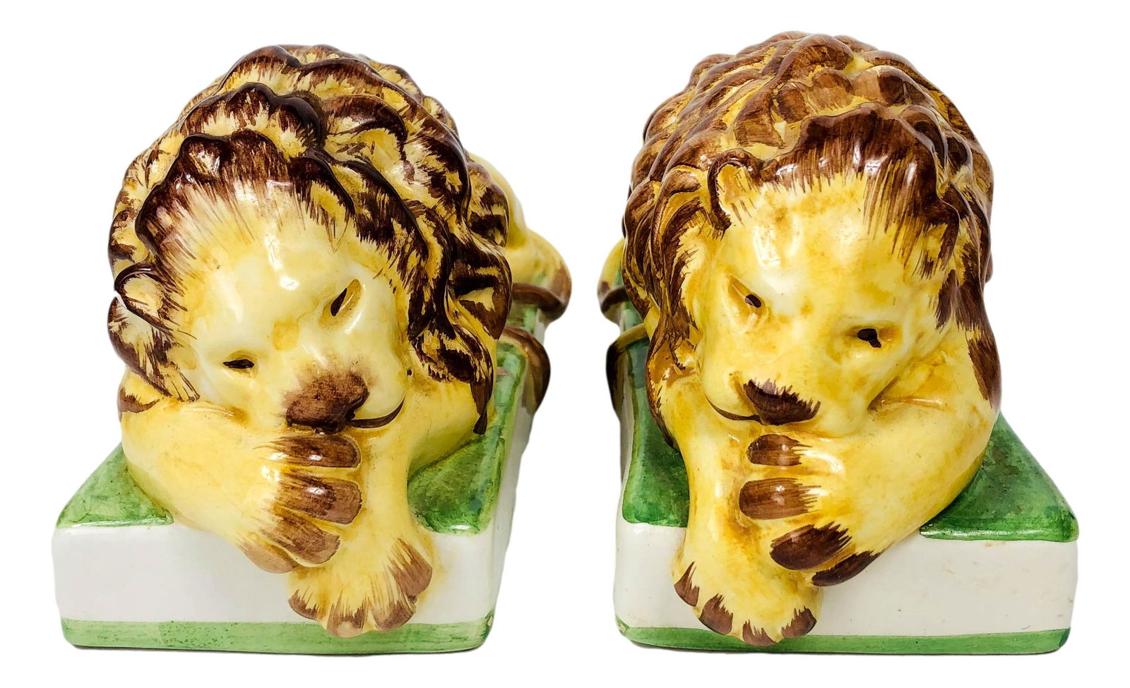 Eximious Italy Ceramic Pottery Lion Figure Bookend: 20th century hand painted ceramic pottery lion figurines / bookends. Each depicts the king of the jungle is reclining / resting pose mounted on a rectangular base. Signed ~ Eximious ItalyDimensions: 4