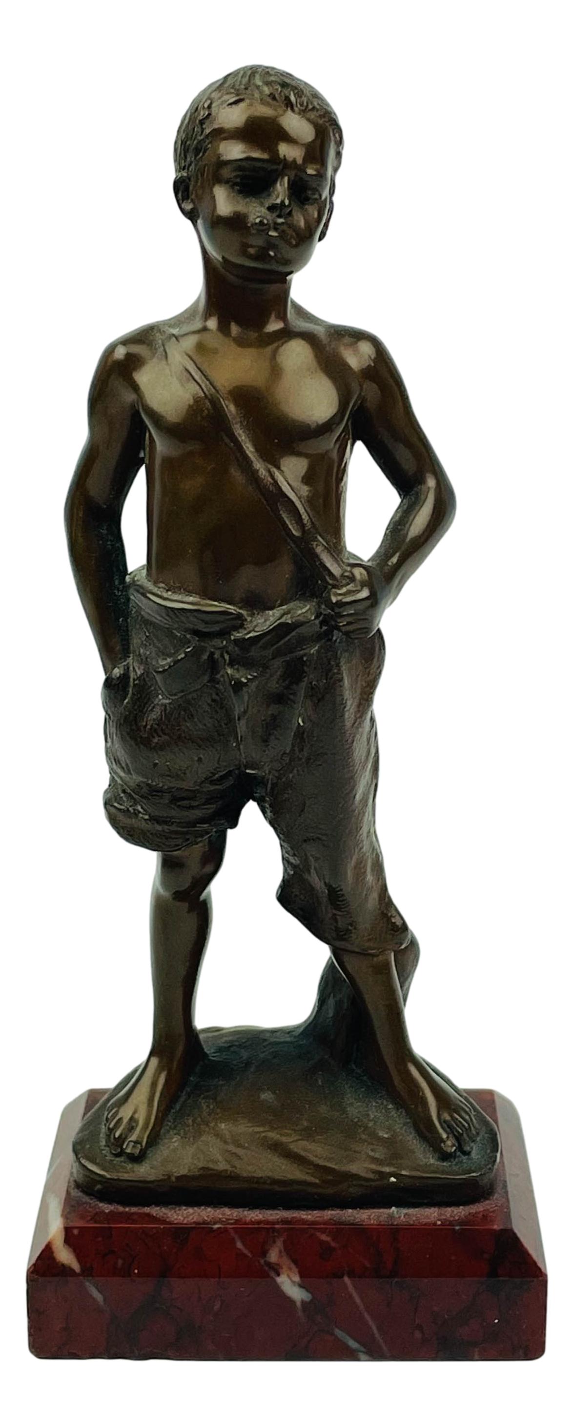 Antique Mini Bronze Boy Sculpture after Herlinger: Antique early 20th century miniature figural bronze boy sculpture after Herlinger. Depicts a young street boy in standing pose, with a cigarette stub in his mouth. Mounted atop a red veined rectangula