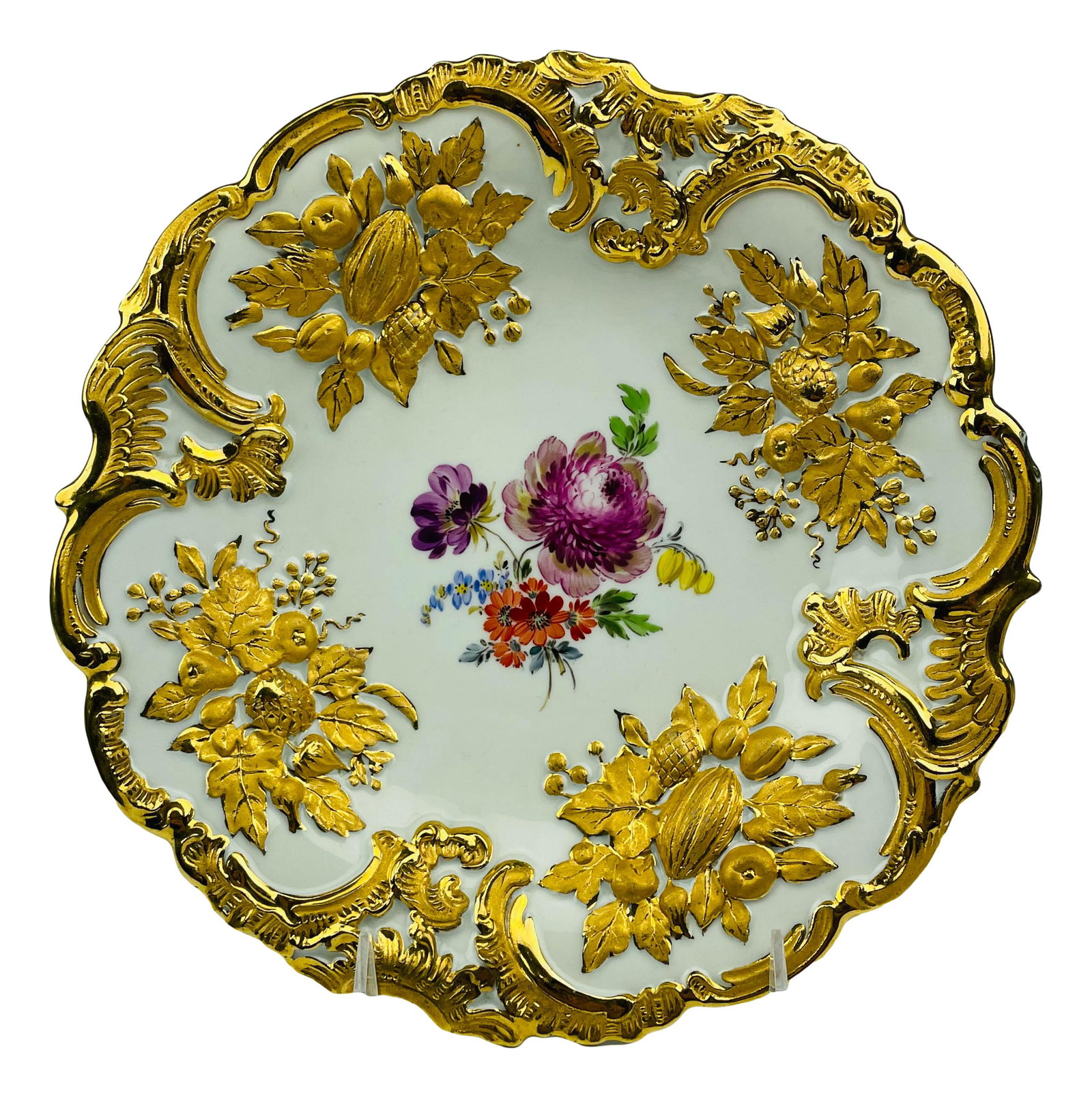 Meissen Gold Gilt Floral Painted Porcelain Plate: Antique Meissen German porcelain curio cabinet display plate. Center features hand painted wild flowers with raised gold gilt floral decoration encasing the art work around against a crisp white groun