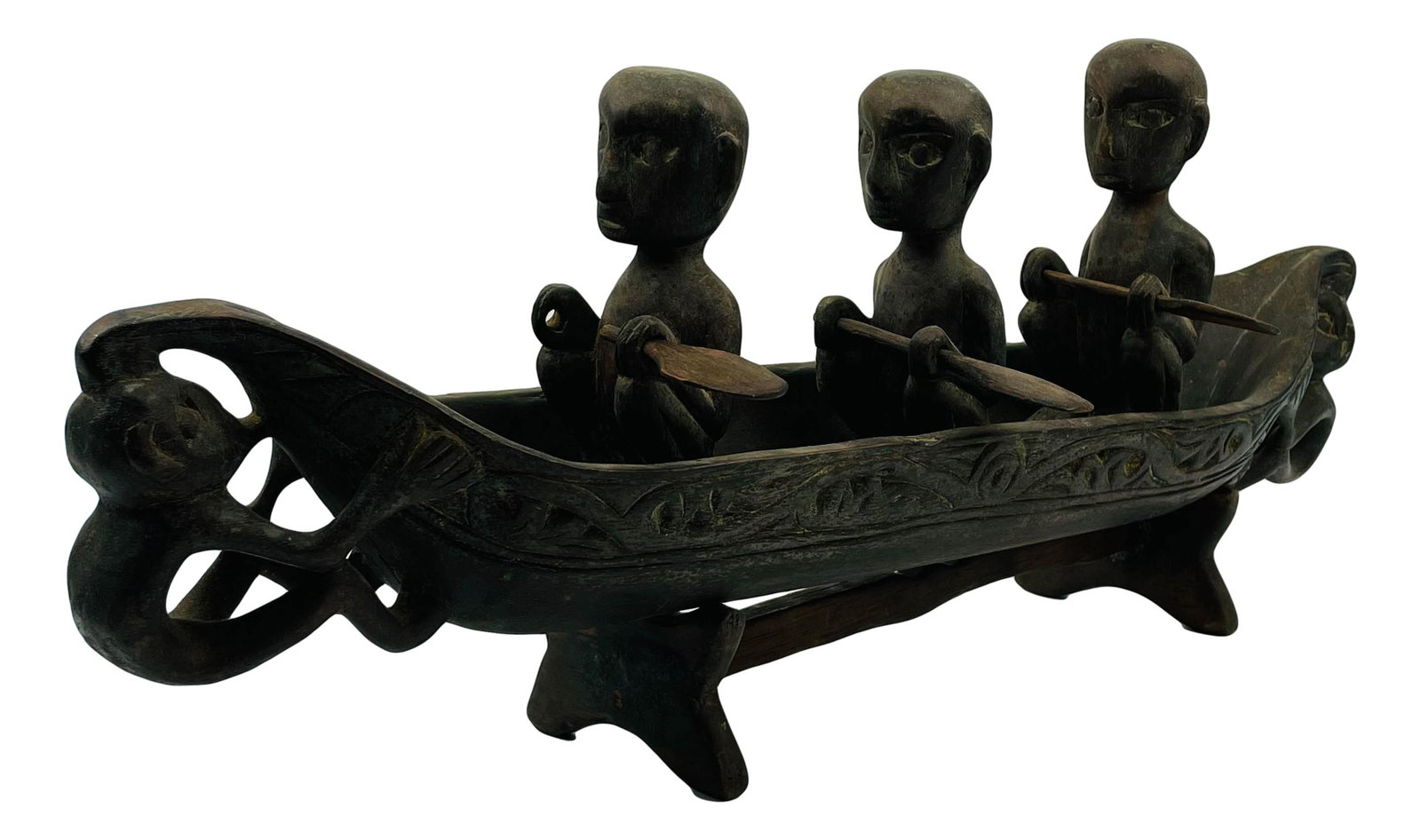 African Folk Art Men in Boat Carved Wood Sculpture: 20th century hand carved tribal primitive article of African cultural art. Depicts 3 men in a row boat. Designed to rest on a wooden stand. No apparent markings. Dimensions: 9.25 X 22 X 4 in. Conditio