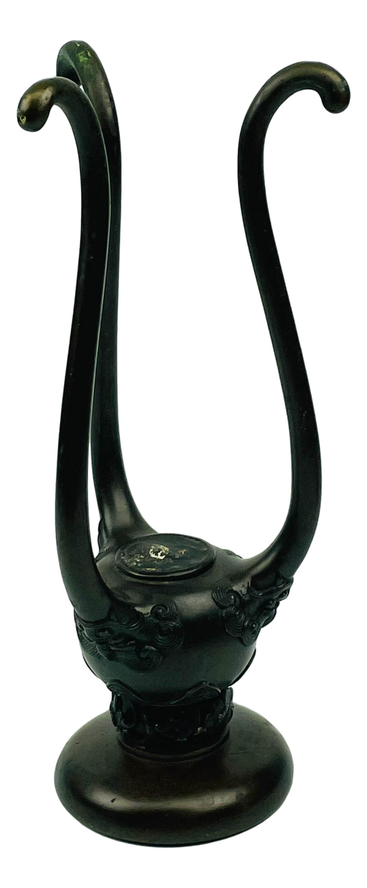 Japanese Bronze Meiji Period Tri Foot Candle Holder: Tri footed Candle Holder with three demonic mask face around with a long tongue like extensions that form the feet. Circular top with central candle opening in the center. Retains its patina. Measures