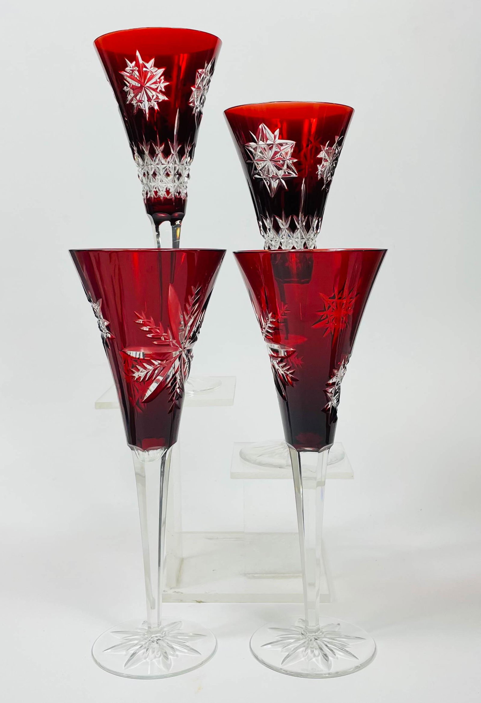 Waterford Crystal Red Cut to Clear Wine Glasses: Waterford crystal set four (4) wine glasses. Ruby red cut to clear. Snowflake Wishes pattern. Two (2) of each snowflake design. Wine glasses are manufacturer marked Waterford on bottom. Dimensions: 9.