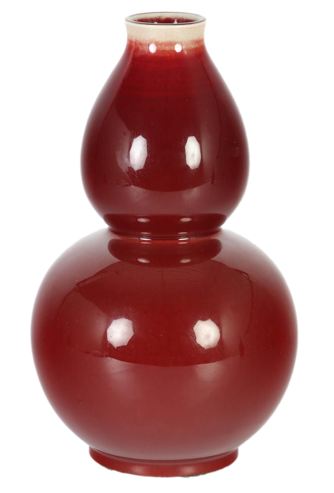 Chinese Sang De Boeuf Oxblood Double Gourd Vase: Porcelain double gourd vase of Chinese cultural art. Graced with a dark crushed strawberry colored ground glaze and a tan coloration at the very top rim, outside and inside. Unglazed rough bottom ring