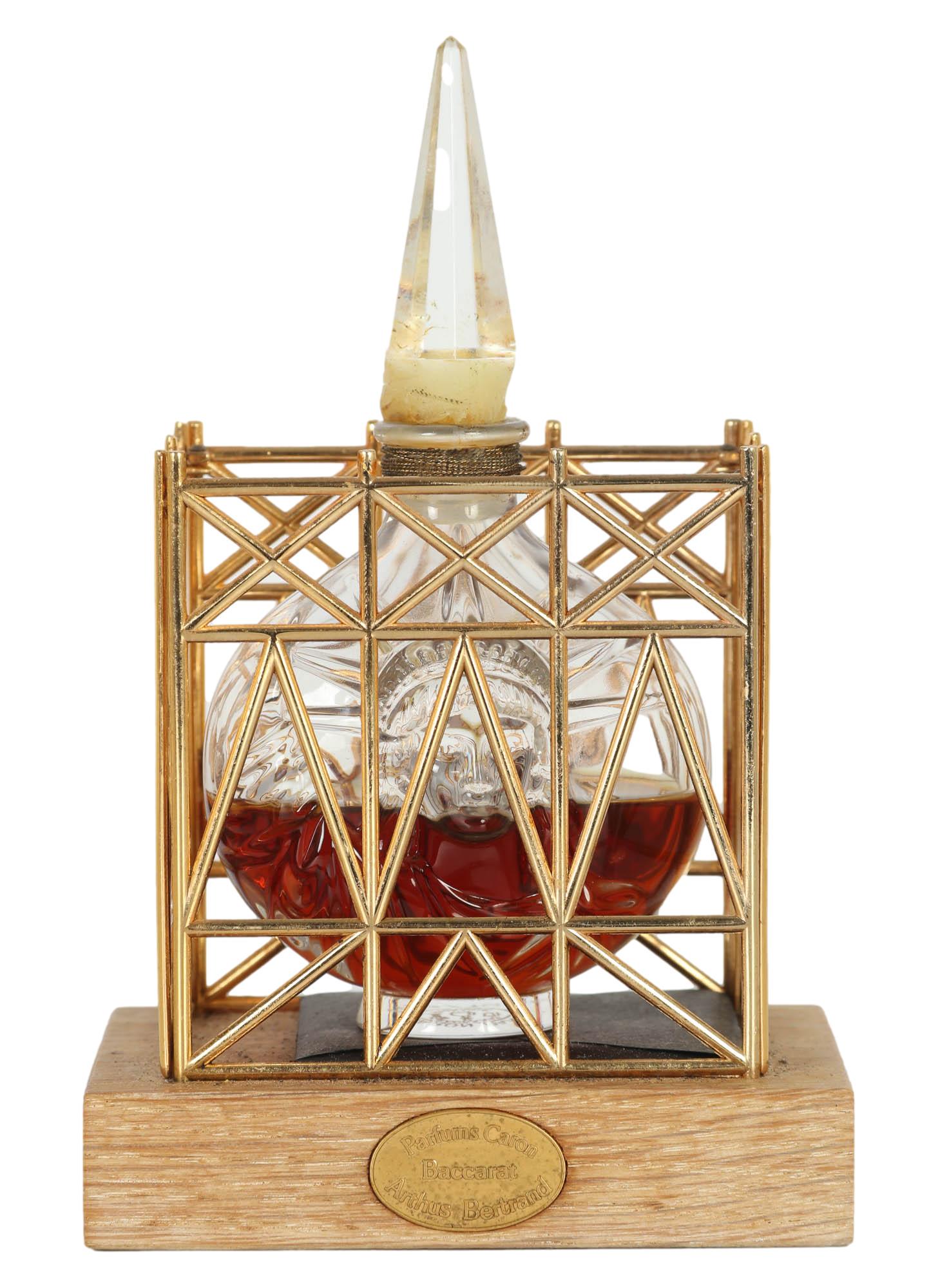 Nocturnes Limited Edition LE Caron Baccarat Bottle: 1986 Limited Edition #208 Baccarat French crystal bottle for Caron "Nocturnes". Bottle is housed in a gold plated scaffolding structure mounted atop a wooden base. The production was apparently discon