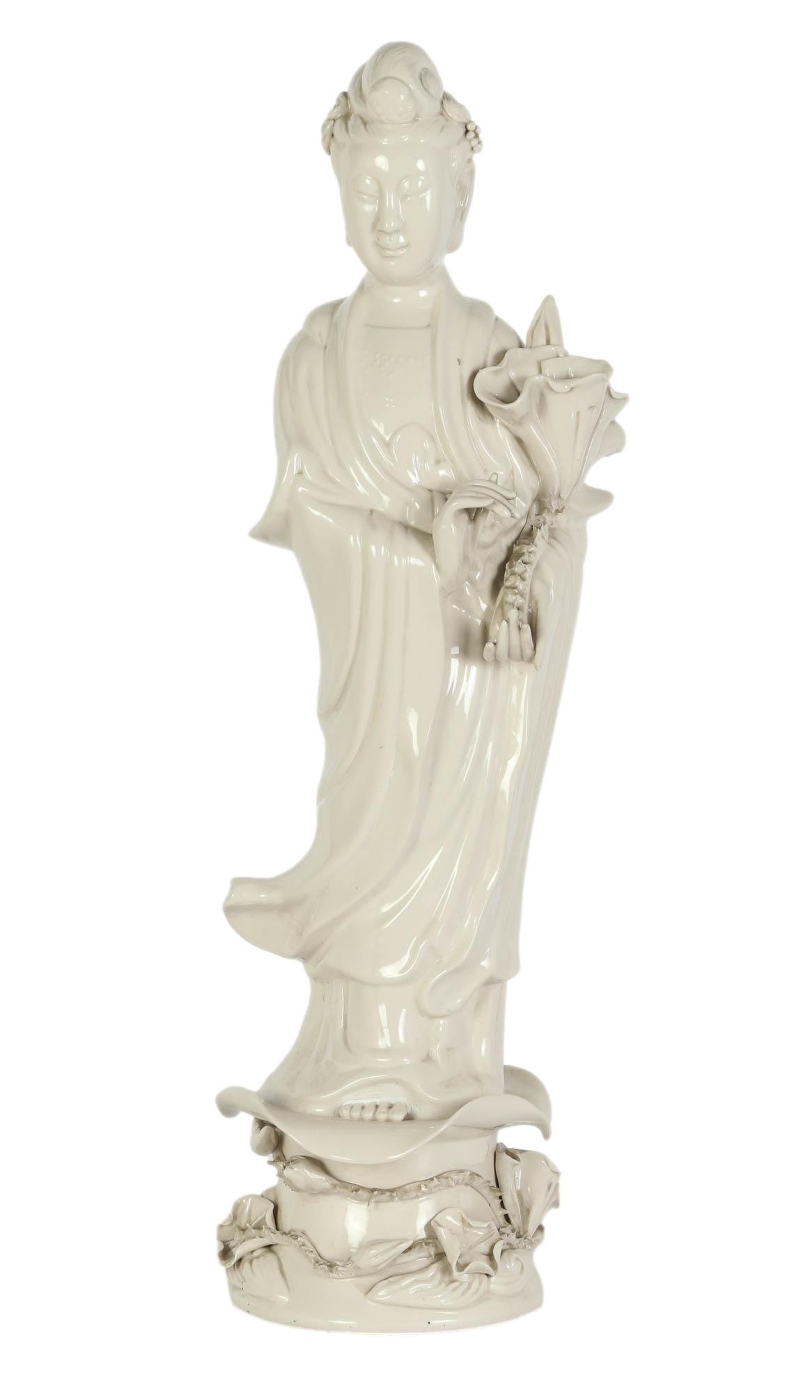 Chinese Blanc De Chine Porcelain Guan Yin Statue: Antique Chinese sculpture of Guanyin. Known as the Bodhisattva goddess of compassion. Sculpture has fine white Blanc de Chine finish. Featured standing on a lotus flower form base, and holding a weepi