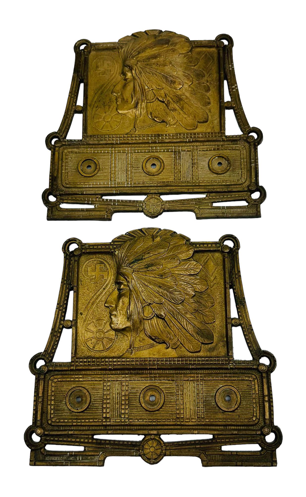 Judd Native American Indian Expandable Book Rack: Antique cast bronze Art Deco metal displays. Depicts the side profile of a Native American Indian Chief in full headdress in crisp relief, a whirling log or swastika (represents well being, good luck