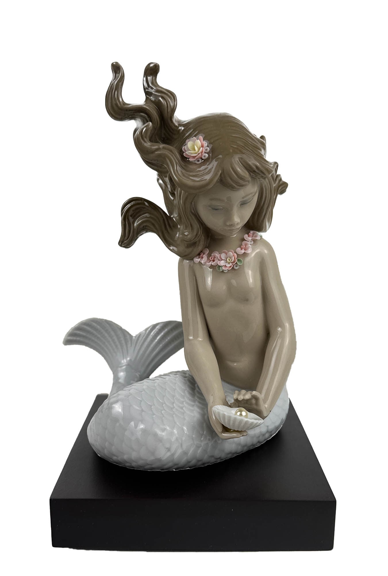 Lladro Mirage # 1415 Porcelain Mermaid Figurine: Titled : Mirage. Model number : 1415. Sculptor : Jose Puche. Issue Year : 1982. Finish : Glazed. Subject matter depicts this mythological fantasy being in seated pose, holding a shell with a pearl in