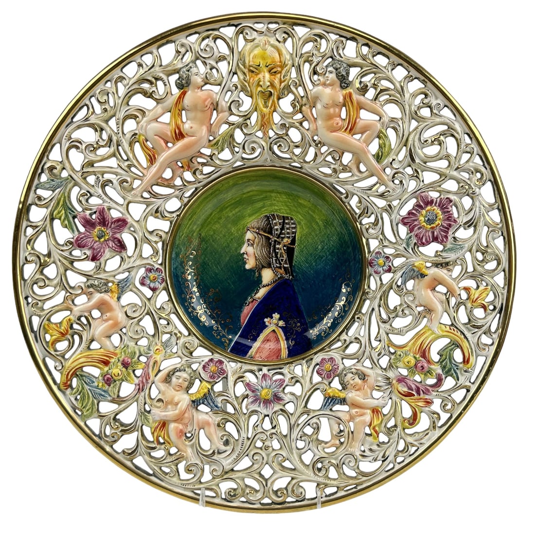 Capodimonte Nude Maiden Cherub Pierced 16" Charger: 20th century Italy Italian hand crafted and painted ceramic pottery wall mount charger. Center features the side profile of a lady in Victorian style garb, the pierced reticulated border with raised r
