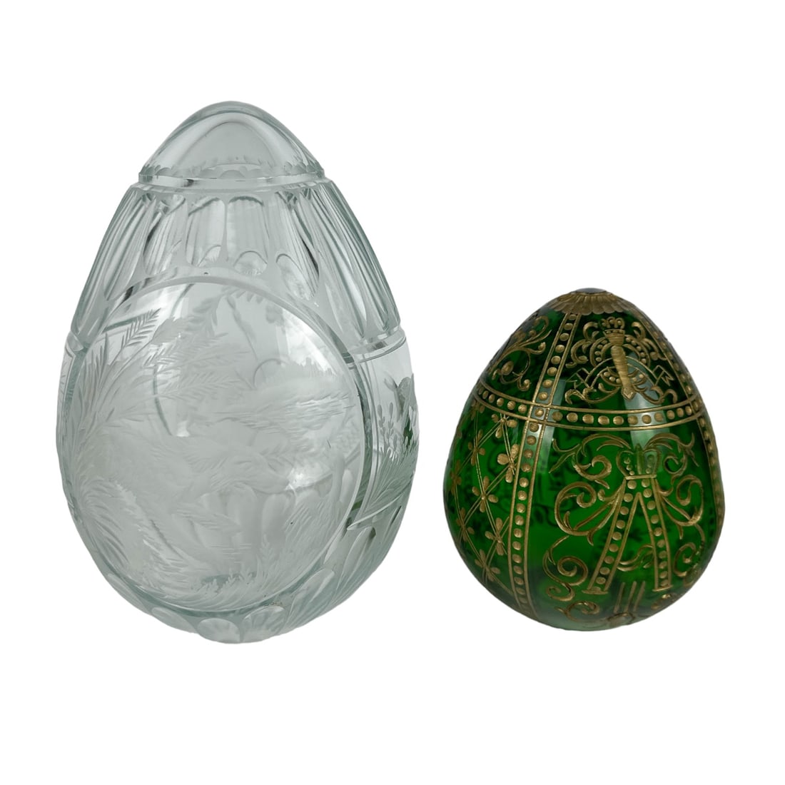 Emerald Green & Clear Glass Etched Russian Egg LOT: Estate lot of 2 art glass articles of Russian cultural art. The green egg graced with decorative etched designs in a dull gold against an emerald green colored ground. The clear egg features dog chasi
