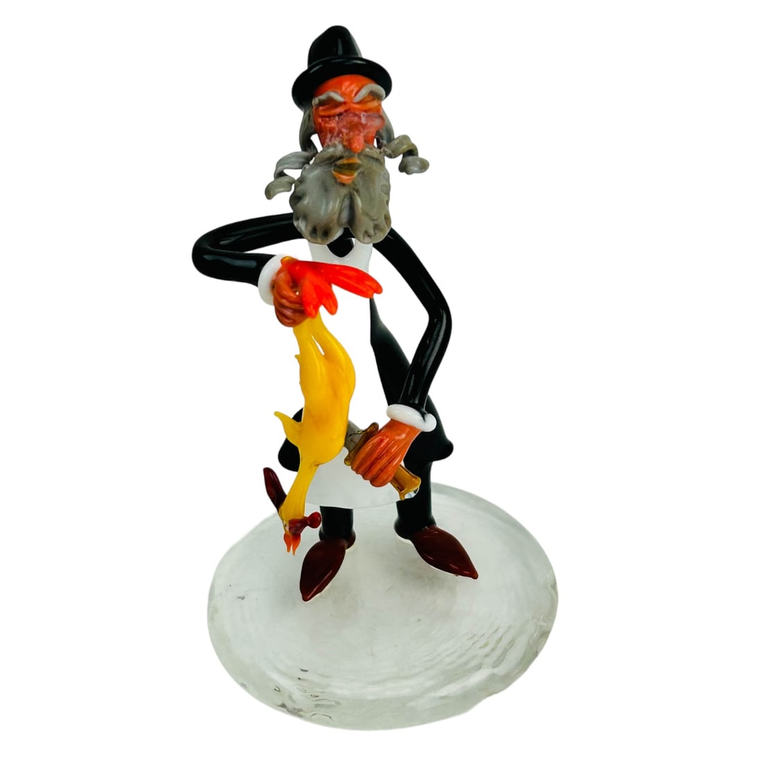 Moretti Raffael Kosher Rabbi Art Glass Sculpture: A postwar 20C Italian Murano art glass lamp work figurine. This Jewish Judaica themed figural work depicts a Rabbi holding a chicken in one hand, a knife in the other. Affixed to a clear glass base. I
