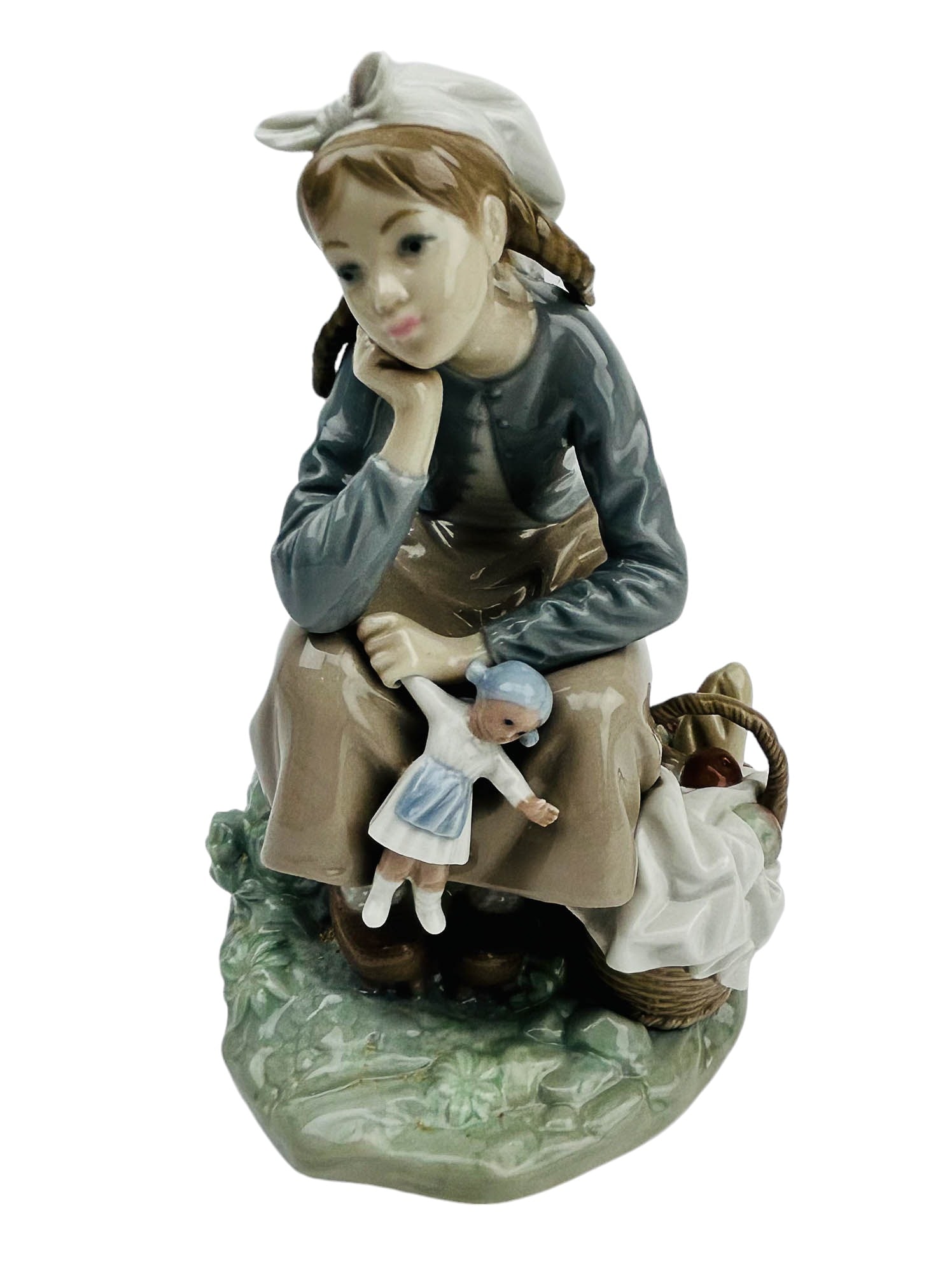 Lladro Spain Girl w/ Doll #1211 Porcelain Figurine: tilted : Girl with Doll. Model number : 1211. Sculptor / Designer : Antonio Ballester. Production Years : 1972 - 1994. Finish : Glazed. Features a seated farmer girl, deep in though, holding her doll 