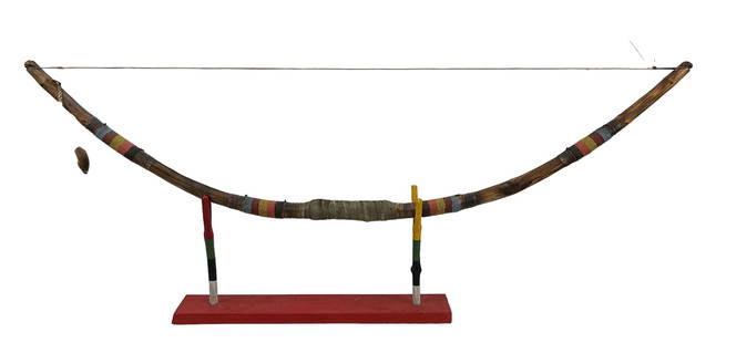 Native American Indian Archery Bow w Display Stand: One of a Kind (OOAK ) handcrafted carved wood, rawhide and beaded bow. Designed to rest on a multicolored Handmade wood stand with a red orange color rectangular wooden base. Measures 42" in length x