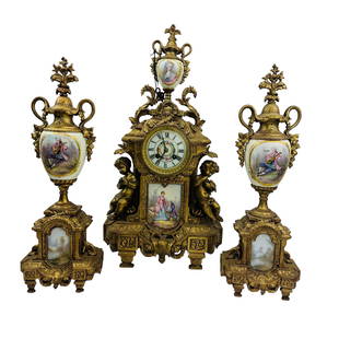 Antique French Bronze Porcelain Clock Garniture 3p: Early 20th century France three (3) piece garniture shelf mantle set. Features an enamel dial face, roman numerals and double key wind to the clock. a heavenly cherub angel on opposite sides. Above