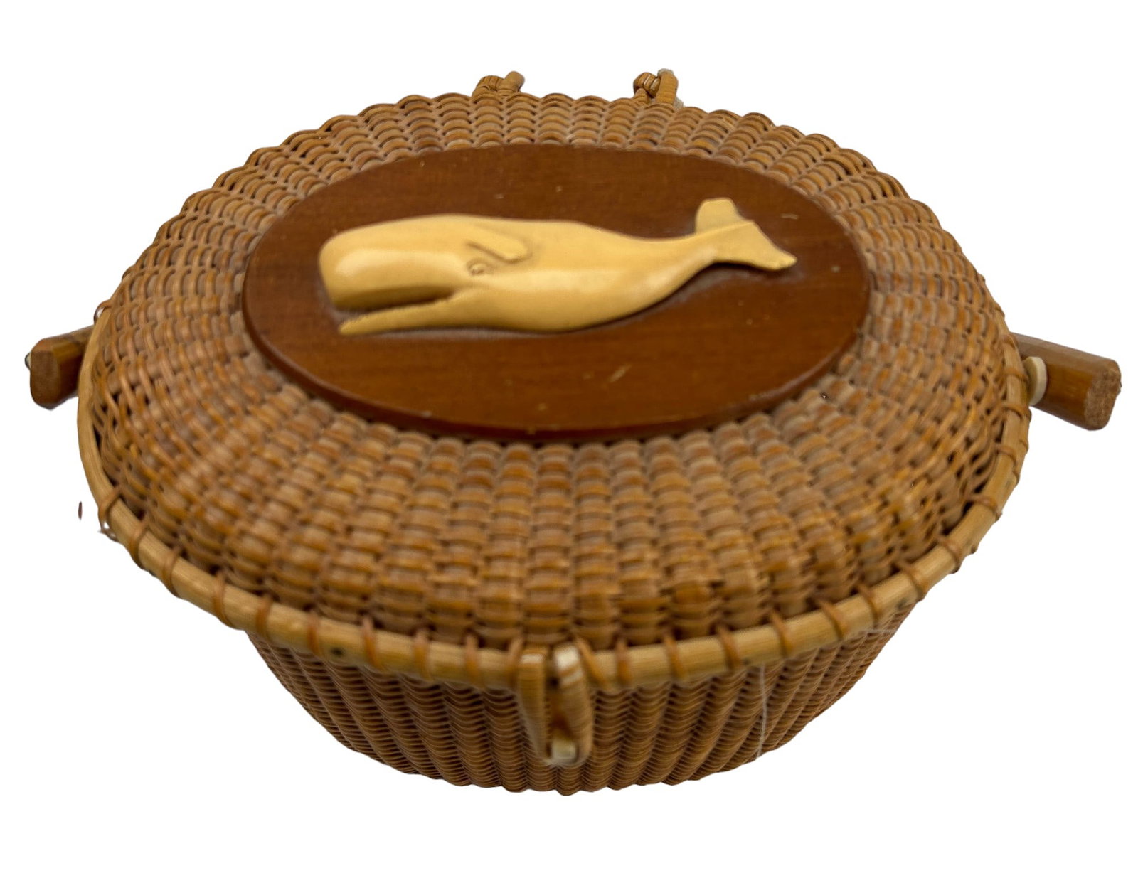 Nantucket Style Woven Basket w/ Whale Scrimshaw: Handcrafted woven basket with swing handle and a three (3) dimensional carved Sperm Whale mounted on an oval wood panel on the lid. Ample storage space within. Light weight in manner. No apparent mark