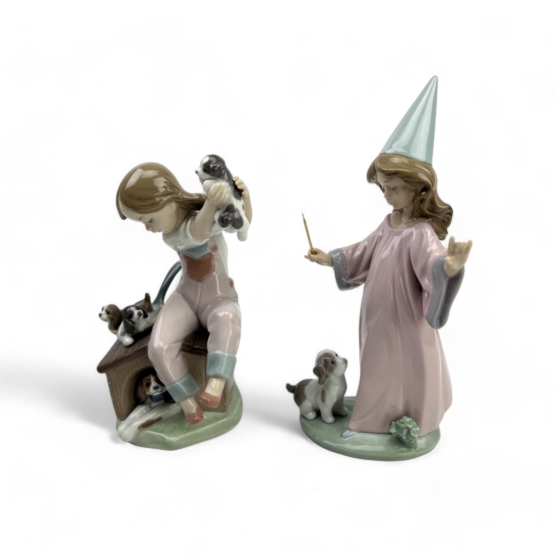 Lladro Under My Spell Pick of Litter Figurines: 2 Lladro figurines. Pick of Litter showing little girl playing with puppies, and Under My Spell which shows a little girl wizard with wand and a puppy dog. Both have Lladro mark on underside. Measure 
