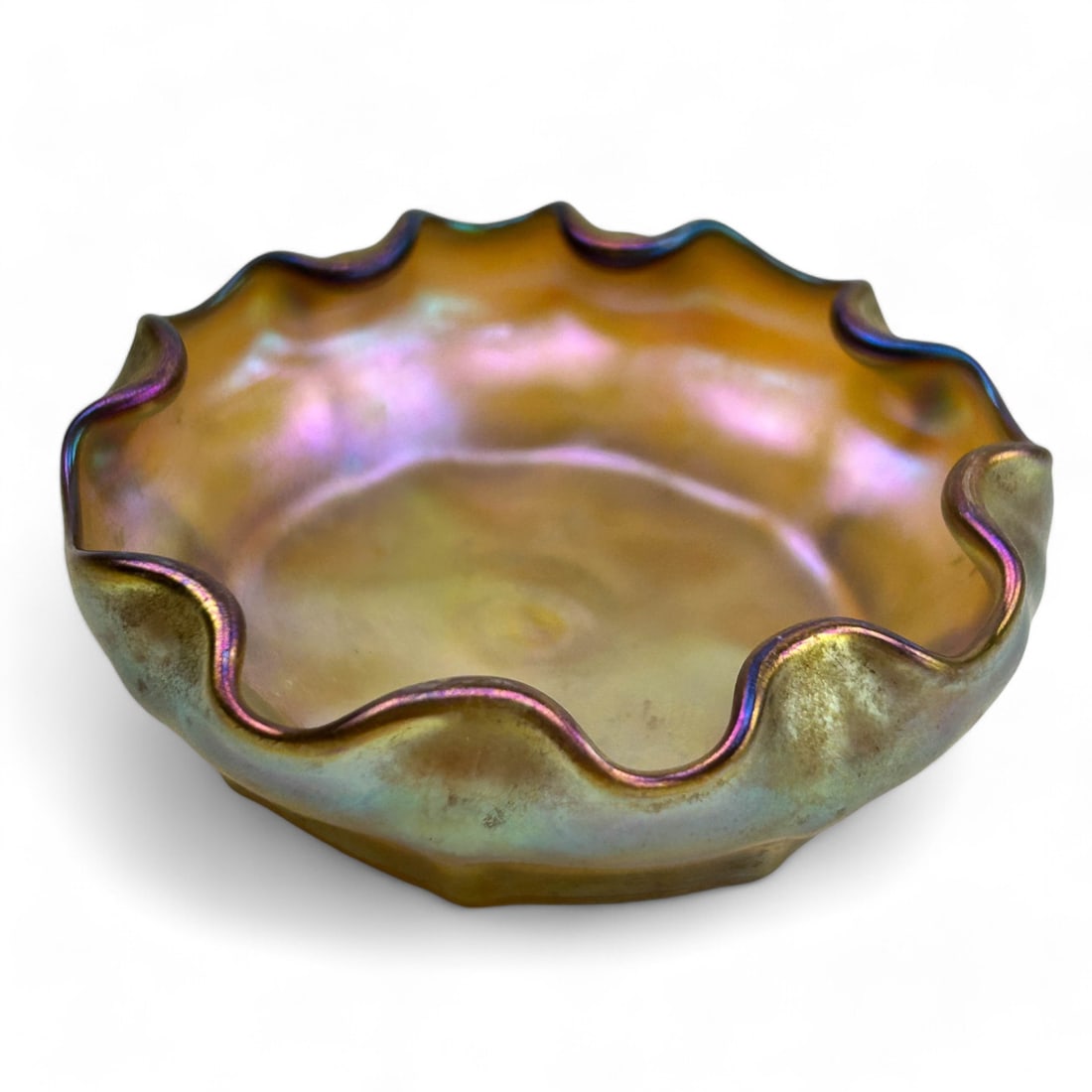 Tiffany Favrile Gold Iridescent Art Glass Salt Dip: A Louis Comfort Tiffany Favrile gold iridescent salt cellar. Featuring a stunning wavy ruffled edge and a vibrant rich iridescence that reflects hues of gold, pink and purple. This piece is a fine exa