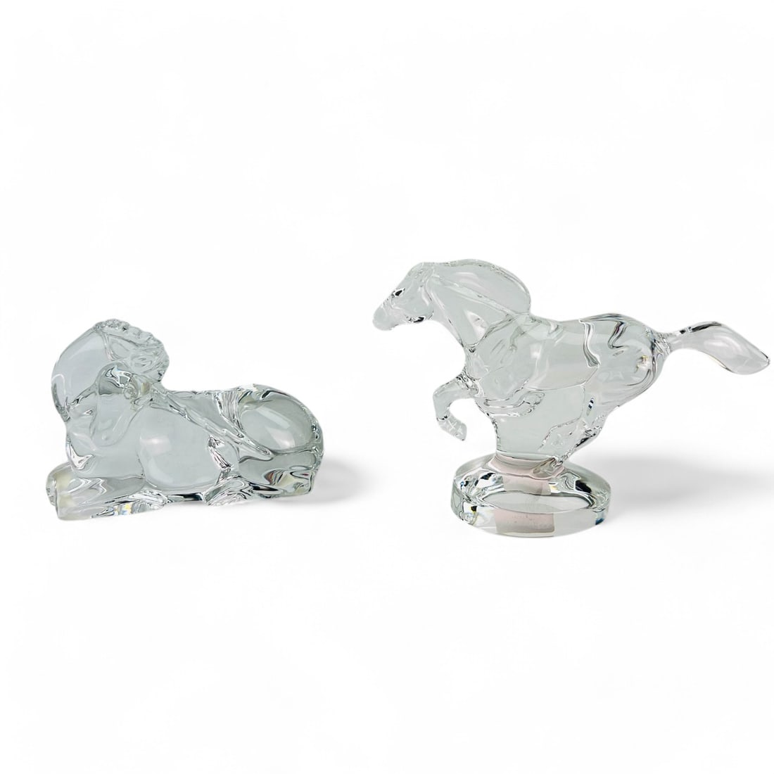 Baccarat Equestrian Crystal Glass Horse Sculptures: Pair of Baccarat France clear crystal art glass equestrian themed figurines. Includes ~ One (1) Gracefully galloping horse in motion on an oval base. One (1) Serene reclining horse. Measure from 3 1/4