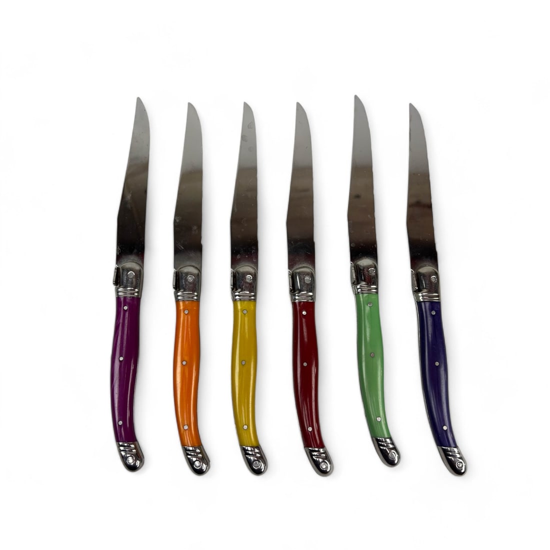 Laguiole Jean Dubost Color Handle Steak Knife Set: Jean Dubost Laguiole set of six steak knives featuring vibrant multi colored handles. Each knife is crafted with stainless steel blades marked with the "Laguiole" insignia, known for its high-quality 