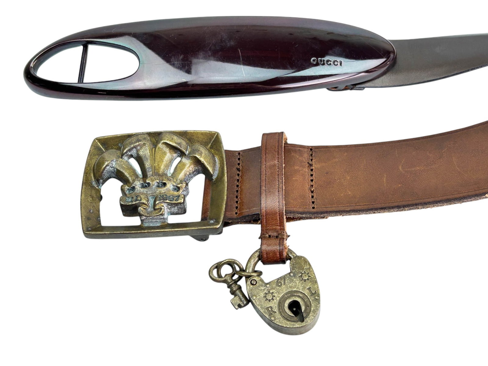 Ralph Lauren & Gucci Buckles w/ Brown Leather Belt: A pair of stylish brown leather belts featuring iconic branded buckles. Includes a Ralph Lauren brown leather belt with a gold tone buckle showcasing a raised emblem design, accompanied by an attached