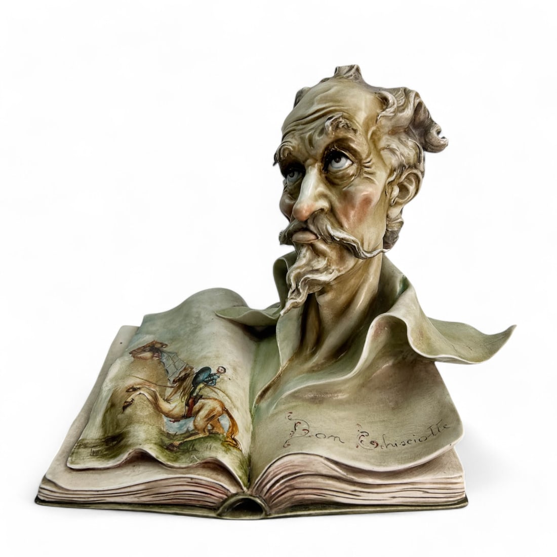 Borsato Bust of Quixote Italian Porcelain Figurine: Antonio Borsato (Italian, 1911 - 1982) Hand Painted Italian Porcelain Bust Sculpture. Showcases a bust of Don Quixote, that emerges from an open book adorned with painted illustrations, capturing a sc