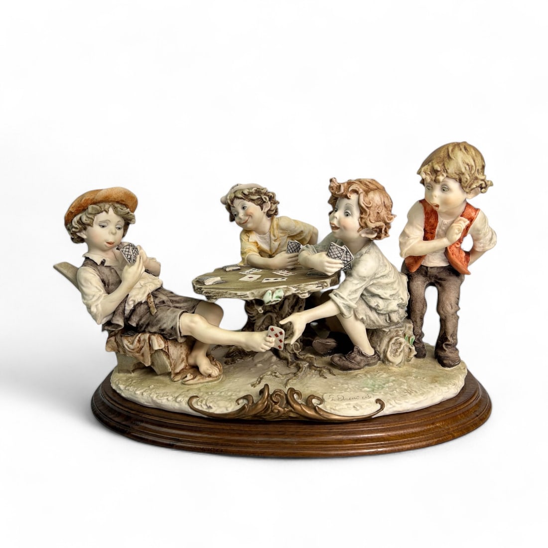 Armani The Cheaters 0280C Capodimonte Sculpture: Giuseppe Armani (Italian, 1935 - 2006) Capodimonte Italy sculpture. Model number 0280C. Work showcases a charming scene of four mischievous children playing cards, with one slyly passing a card under