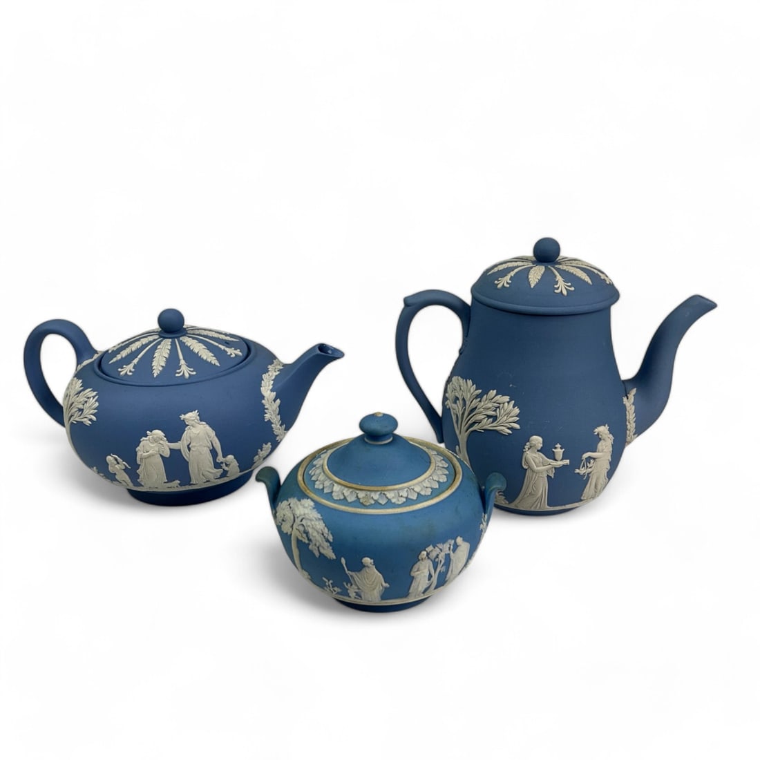 Wedgwood Jasperware Tea Coffee Pot Sugar Bowl 3pc: Estate lot of a total of three (3) Wedgwood England blue jasperware table ware servers. All feature Neoclassical scenes and motifs including maidens in flowing gowns, deer, nude winged cherubs and hea