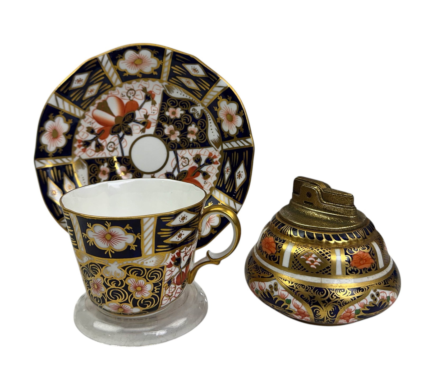 Royal Crown Derby Bone China Teacup Saucer Lighter: Royal Crown Derby English Bone China Display articles. Includes ~ A matching teacup and saucer in the Traditional Imari pattern (1891 - 2014). A cigarette table lighter in the Old Imari pattern 1901 -
