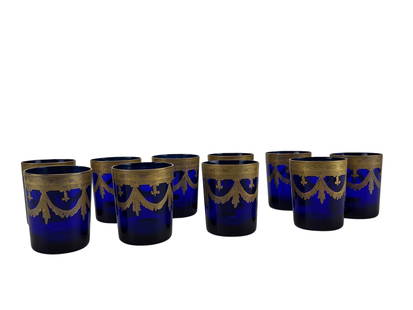 Reims France Cobalt Blue Gold Gilt Glasses Set 10: Mid century modern set of 10 Reims France bar barware glass tumblers. Each features a deep blue body with an ornate gold gilt neoclassical swag and ribbon motif along the rim. Signed ~ stamped on the