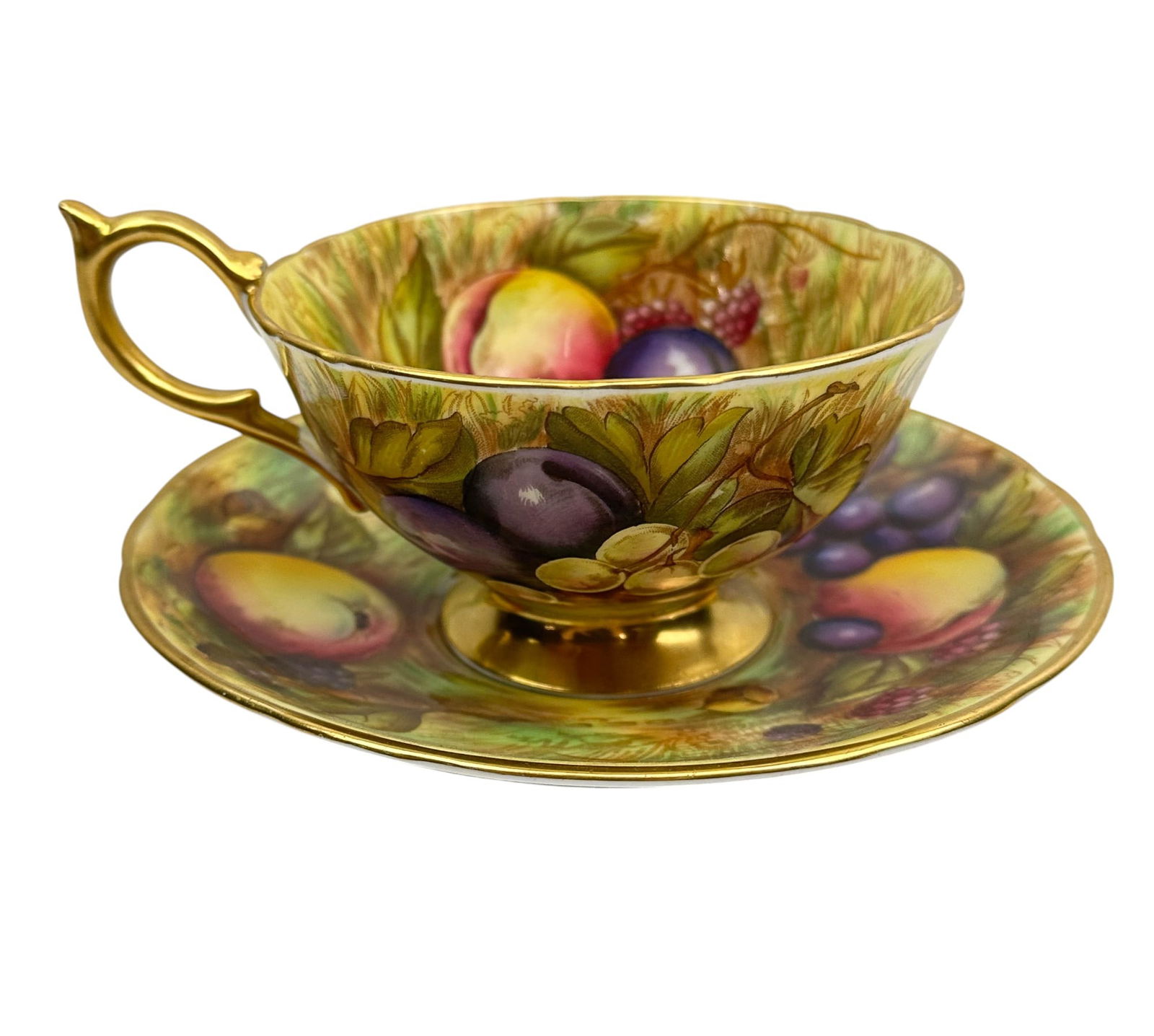 Aynsley Orchard Gold English China Tea Cup Saucer: Aynsley England bone china curio cabinet teacup and saucer display set. Modeled in the Orchard Gold pattern. Circa 20th century. Both showcase a harvest scene of ripened and luscious fruits, grapes, b