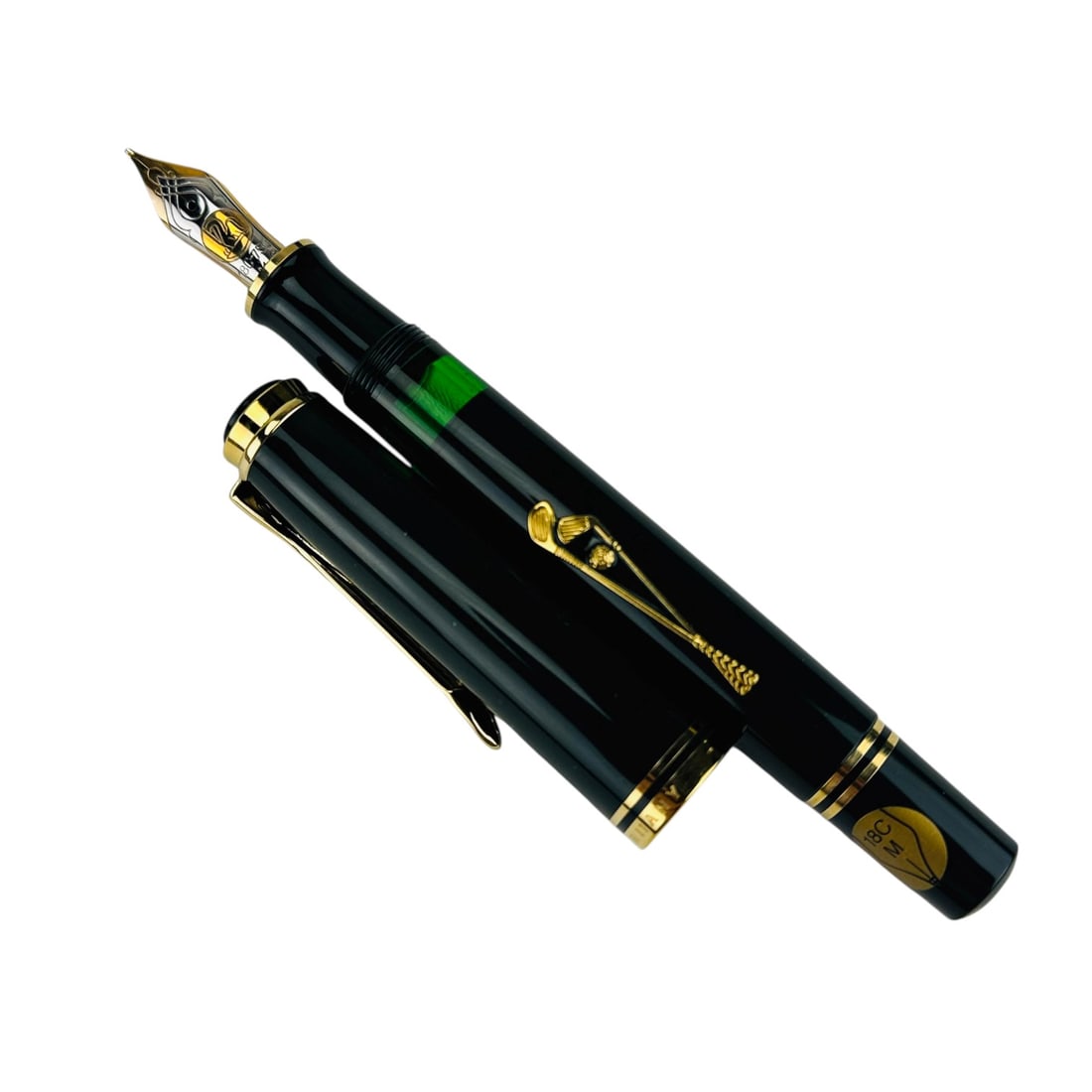 Pelikan Golf 18K Gold LE Fountain Pen Original Box: Luxury designer desk top writing pen instrument features a black lacquered barrel with gold plated golf club clip detail and Pelikan emblem. The nib is marked 18C-750 medium and bears the Pelikan logo
