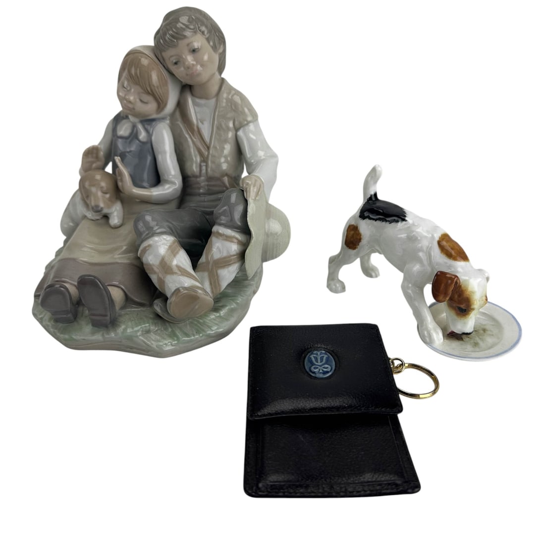 Lladro Friendship, Keychain & Doulton Dog Figurine: Group lot of two (2) decorative Spanish and English porcelain collectibles and a functional black leather article. Includes ~ one (1) Lladro Spain Friendship figurine. Model number 1230. Designed by s