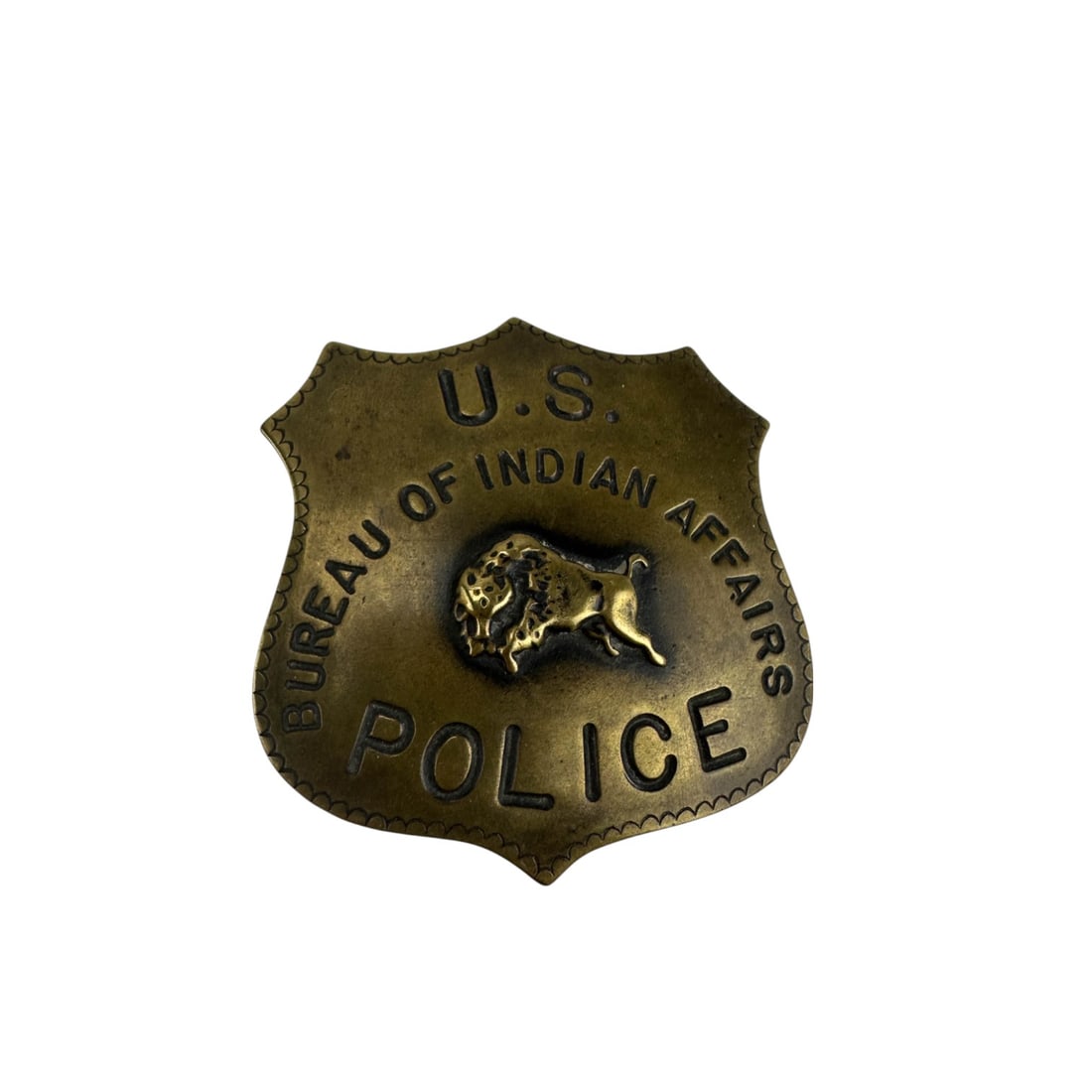 US Bureau of Indian Affairs Police Metal Badge Pin: U.S. Bureau of Indian Affairs Police badge pin in shield form with raised buffalo motif and stamped lettering. The badge is made of metal with a single horizontal pin clasp on the reverse. Signed ~ im