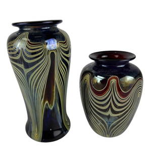 Marc Boutte Pulled Feather Studio Art Glass Vases: Pair of late 20th century studio hand blown art glass vases by Marc Boutte. Feature iridescent plum and navy ground and pulled feather designs in pale green and white. Interiors cased in deep ruby red