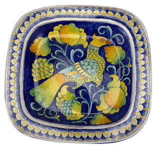 Italian Majolica Bird of Paradise Ceramic Charger: 20th century Italian majolica ceramic hand painted art pottery charger with a central depiction of a stylized bird of paradise among yellow and green floral scrolls, set against a deep cobalt blue gro