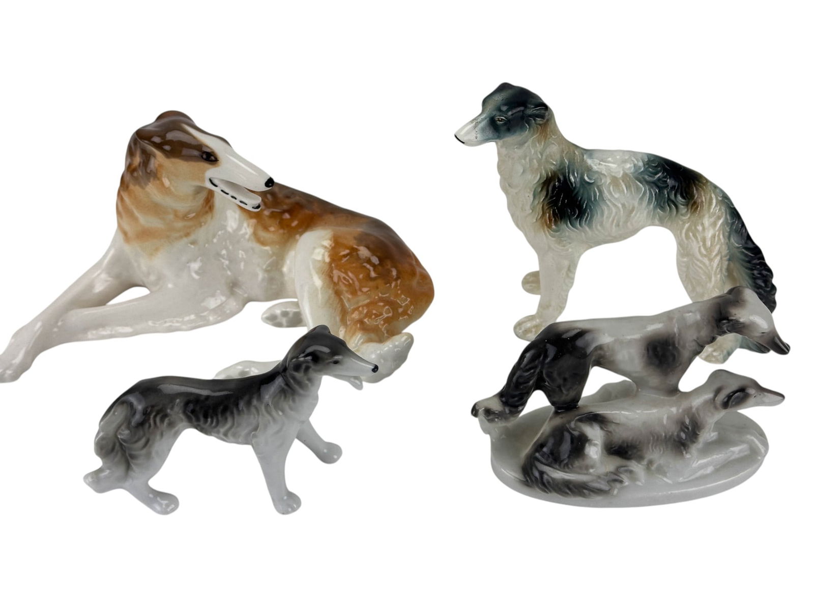 USSR Japan Porcelain Borzoi K9 Dog Figurines 4pc: 20th century hand painted porcelain Borzoi / Afghan hound dog figurine group, comprising four pieces in various poses and finishes. Includes one reclining Borzoi marked Made in USSR with russet and wh