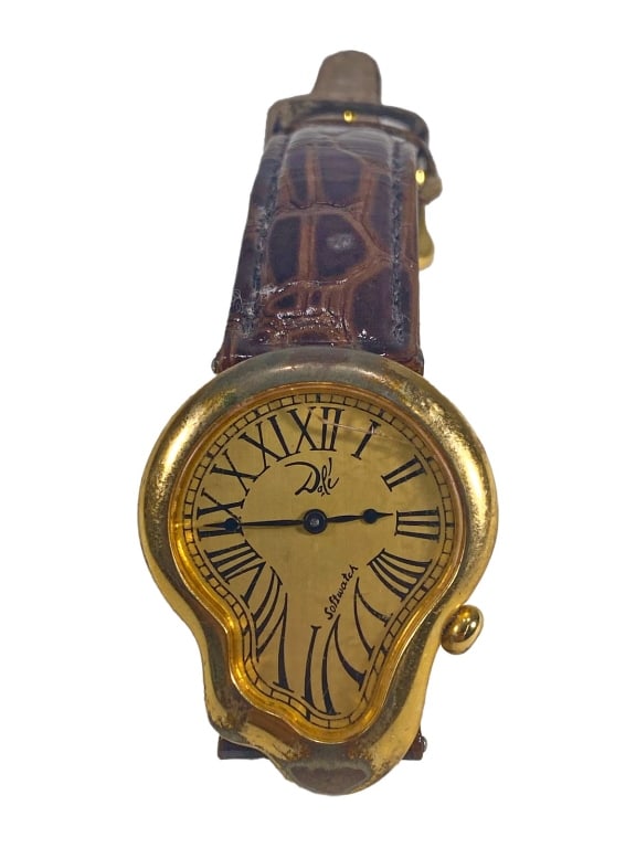 Softwatch Salvador Dali Swiss Made Uni Wristwatch: Surrealist style Swiss made unisex wristwatch inspired by Salvador Dali (Spanish, 1904-1989) and his iconic melting clock motif. The asymmetrical gold-tone case frames a Roman numeral dial and inscrib