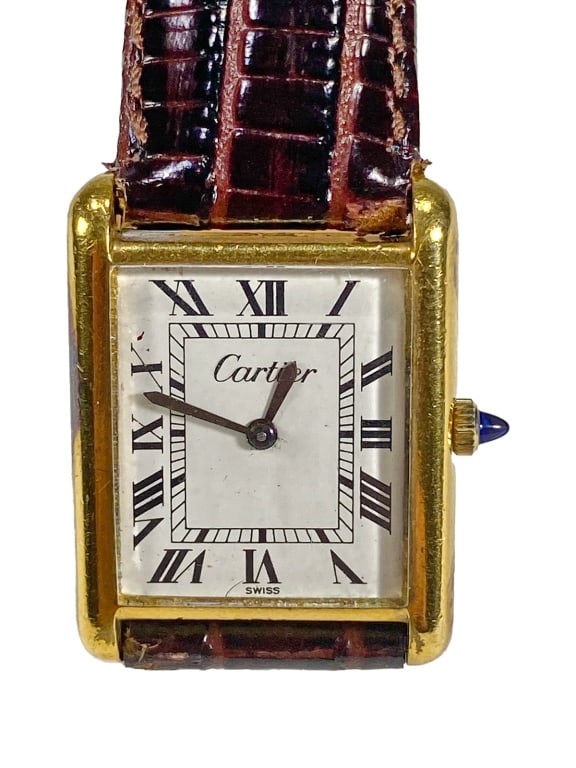 Cartier Tank Gold Plated Wristwatch Roman Numerals: Cartier Tank Swiss made wristwatch with an 18K yellow gold electroplated rectangular case and white dial featuring bold Roman numeral hour markers. Fitted with blue steel hands and a cabochon-set crow