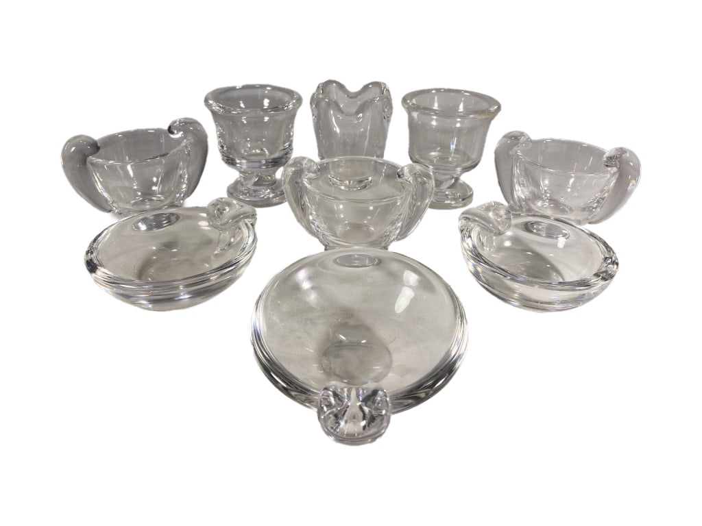 Steuben Crystal Ashtrays, Bowls & Vases 9pc Group: A Steuben collection of nine clear 20th century American crystal items. Including small bowls, ashtrays, footed vases, and handled bowls. Various forms with scroll handles and thick bases. Each piece