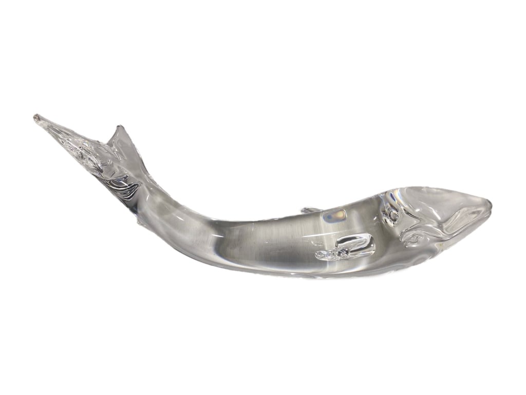 Steuben Clear Crystal Art Glass Whale Sculpture: A Steuben streamlined clear crystal whale figure with molded fins and a flared tail. The minimalist form emphasizes fluid motion throughout this sculpture. Signed in script 'Steuben' on its body.Dimen