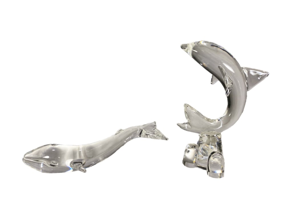 Steuben Crystal Art Glass Whale & Dolphin Figures: Steuben, lot of two clear crystal sea life sculptural figurines. Including a streamlined whale and a leaping dolphin on a four-pad base. Etched 'Steuben' signatures are present on each figure. The lar