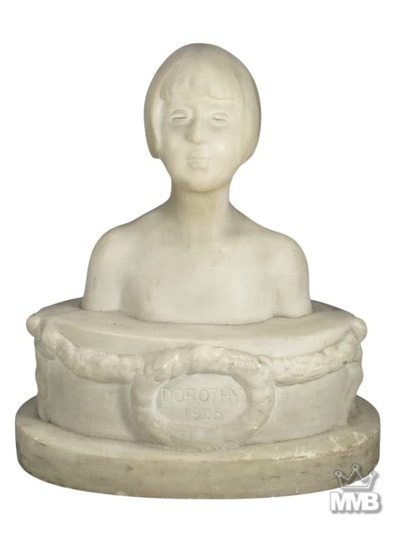 Antique European Carved Marble Girl Bust Sculpture: Antique European marble bust sculpture of a young girl'. Inscribed 'Dorothy 1925', mounted on a rounded plinth with garland and putto relief.Dimensions: 11.25 X 9.5 X 5.75 in. Condition: Good over