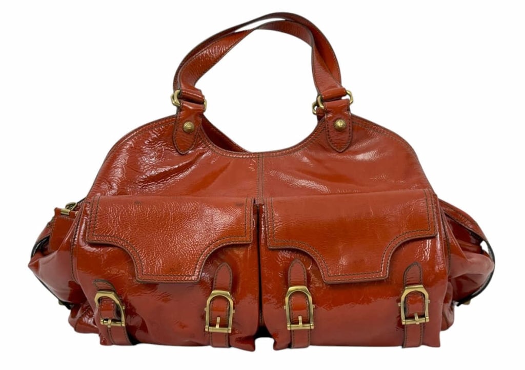 Escada Glossy Red Patent Leather Buckle Tote Bag: Escada designer tote handbag purse crafted in glossy red patent leather with brass-tone hardware. Features dual rolled handles, two front flap pockets with buckle closures, and side compartments. The