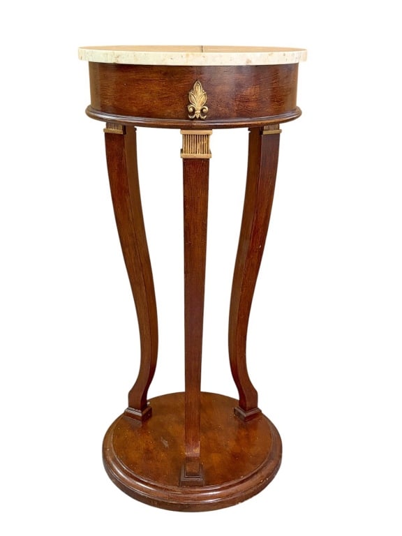 Elegant Marble Top Mahogany & Bronze Pedestal: Marble top mahogany pedestal with gilt bronze fleur-de-lis and fluted accents, raised on three curved legs over a round plinth base.Dimensions: 34.25 X 16 X 16 in. Condition: Good overall conditio