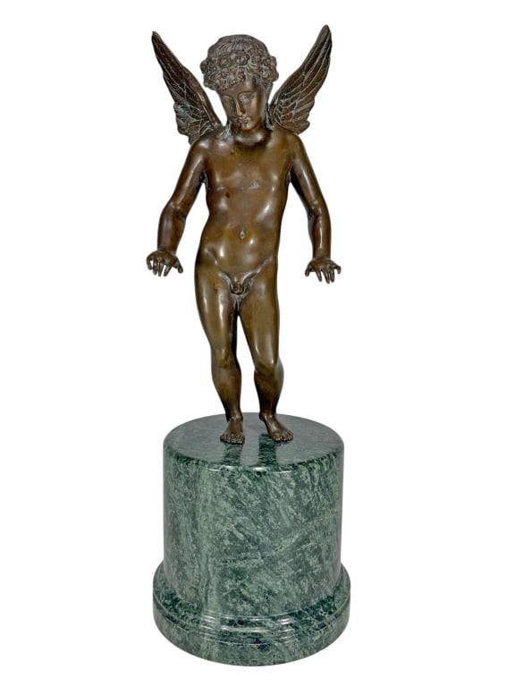 Cupid Bronze Sculpture with a Green Marble Base: Finely cast bronze of Cupid as a nude winged youth with curled hair and feathered wings, mounted on a cylindrical green marble base. Dimensions: 20 X 6.25 X 6.25 in. Condition: Good overall conditi