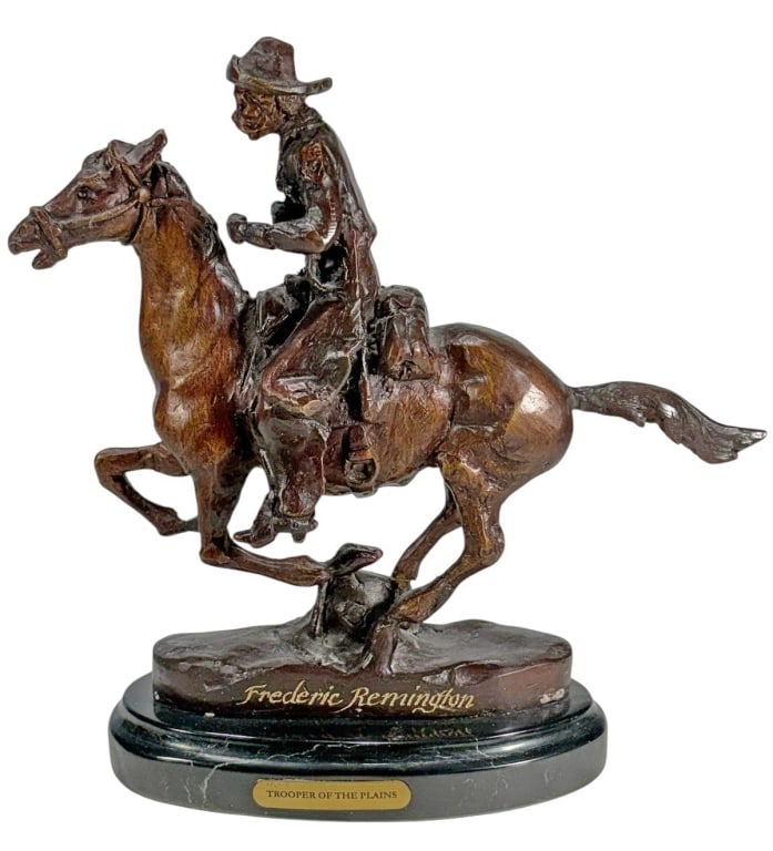 Trooper of the Plains after Frederic Remington: Frederic Remington (American, 1861-1909) bronze-finish sculpture depicting a mounted cowboy in motion, set on an oval black marble base with engraved title plaque 'rooper of the Plains'.Dimensions: 9.