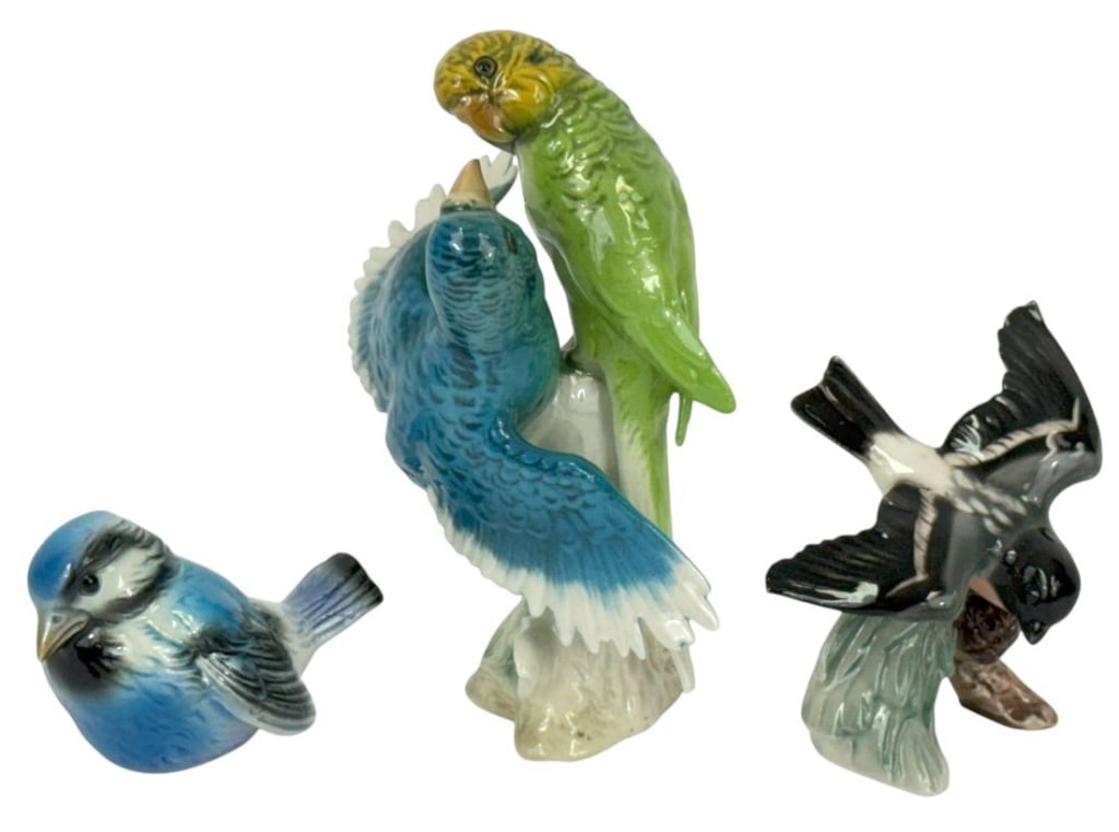 Goebel West Germany Porcelain Bird Figurines 3pcs: Lot of three Goebel, West Germany porcelain bird figurines. Including a blue tit, a pair of budgerigars perched on a branch and a swallow in flight. Each piece is hand-painted in naturalistic colors a