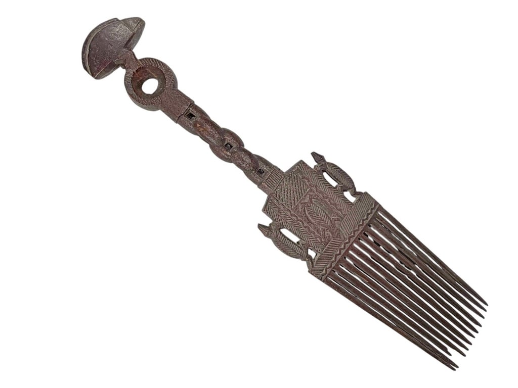 Rare Hand Carved Wooden African Comb: Elongated wooden comb with carved geometric and symbolic patterns, chain-like handle, semicircular finial, and dark patina. Dimensions: 19 X 4 X 1 in. Condition: Good overall condition having norma