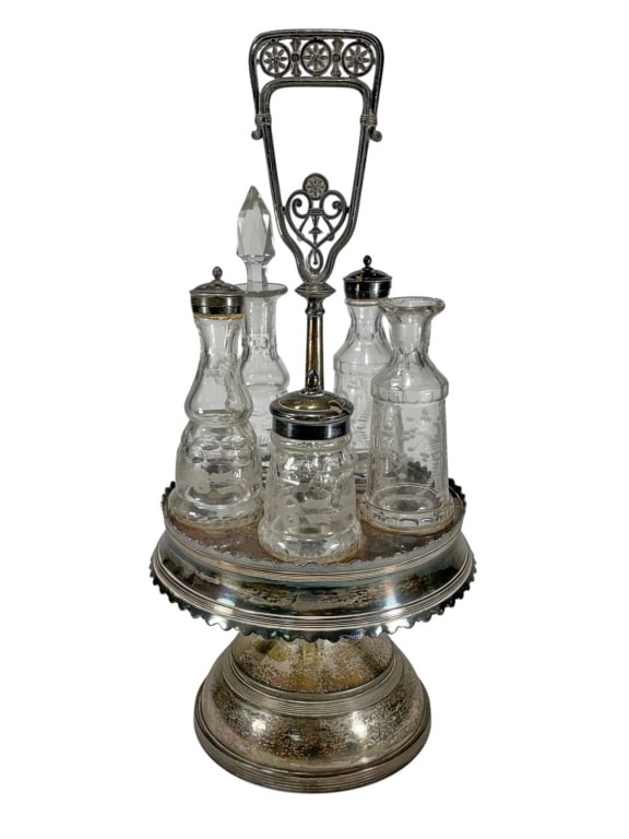 Reed & Barton Silverplate & 5 Glasses Cruet Set: Reed & Barton silverplate cruet set with scalloped rotating base and ornate pierced handle. Includes five etched glass bottles. Base stamped 'MFD & PLATED BY REED & BARTON no. 3875.' The largest measu
